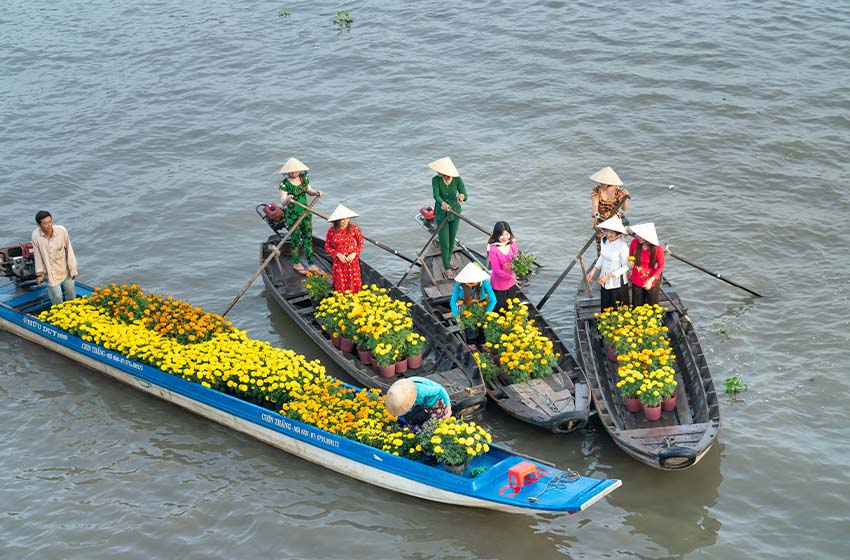 Mercado flotante en el Delta del Mekong con barca de flores